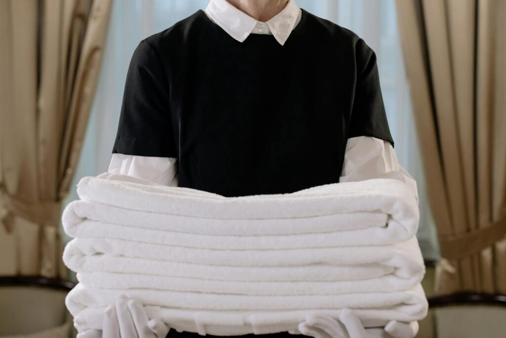 Person Holding a Stack of White Towels